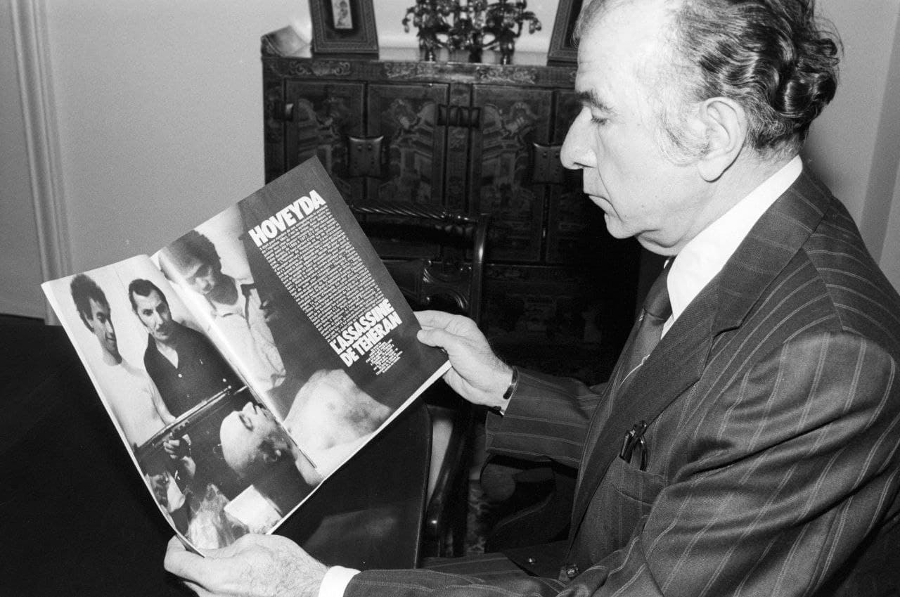 فریدون هویدا به عکسی از جنازه برادرش امیرعباس هویدا در سردخانه که در یک مجله فرانسوی منتشر شده، نگاه میکند.
*امیرعباس هویدا در ۱۸ فروردین ۱۳۵۸ اعدام شد.